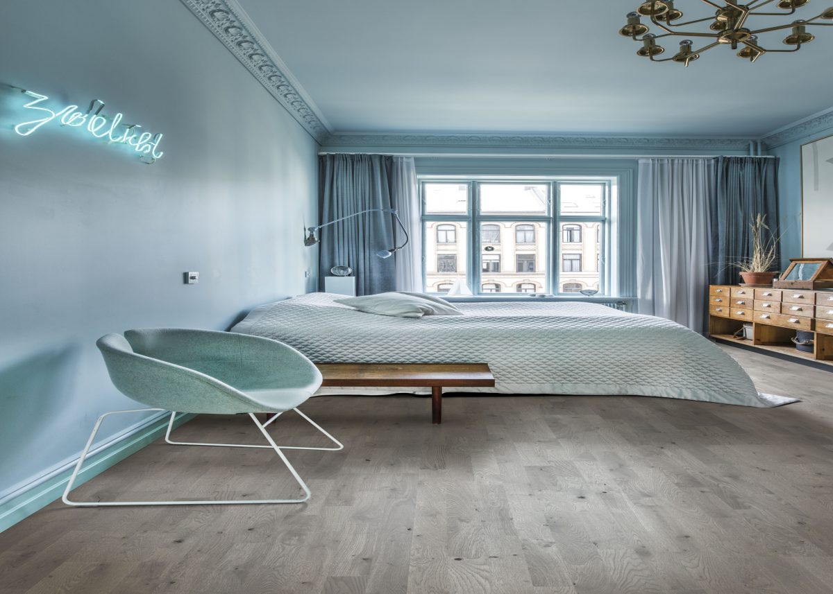 Decorated bedroom space with Kahrs Charcoal Light Plank Prefinished Hardwood.